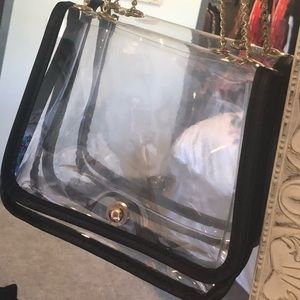 Clear purse with a black leather rim.